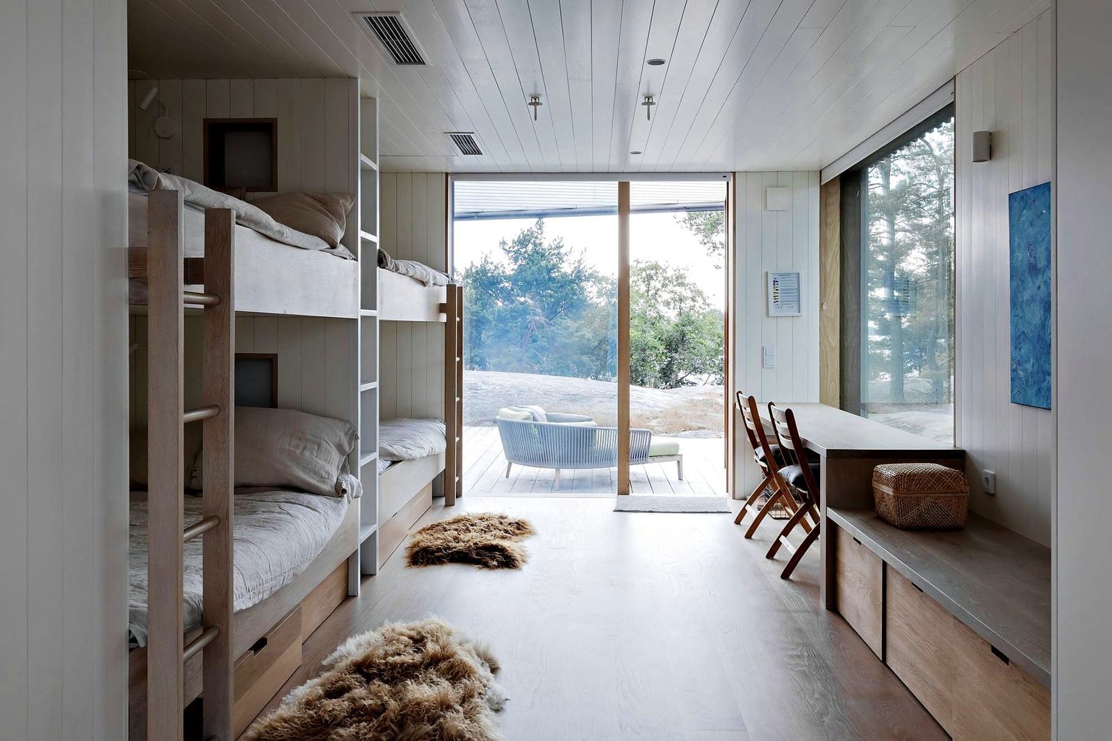 Two bunk beds in pale oak, a window seat and a glass wall onto the rock